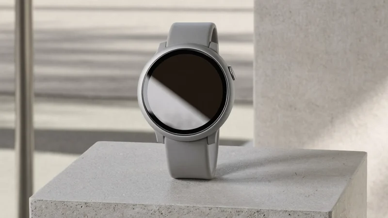 Illustration einer runden Smartwatch mit grauem Silikonarmband auf Betonblock