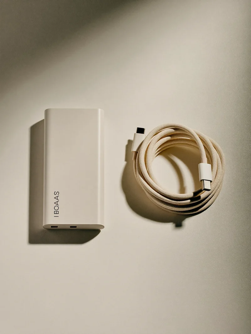 Illustration einer flachen Powerbank mit aufgerolltem USB-C-Kabel von oben